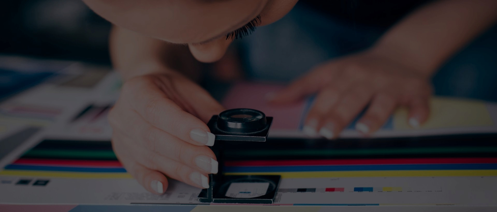 designer inspecting document print magnifying lens