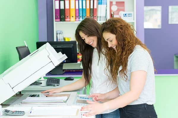 two female students using a printer photocopier