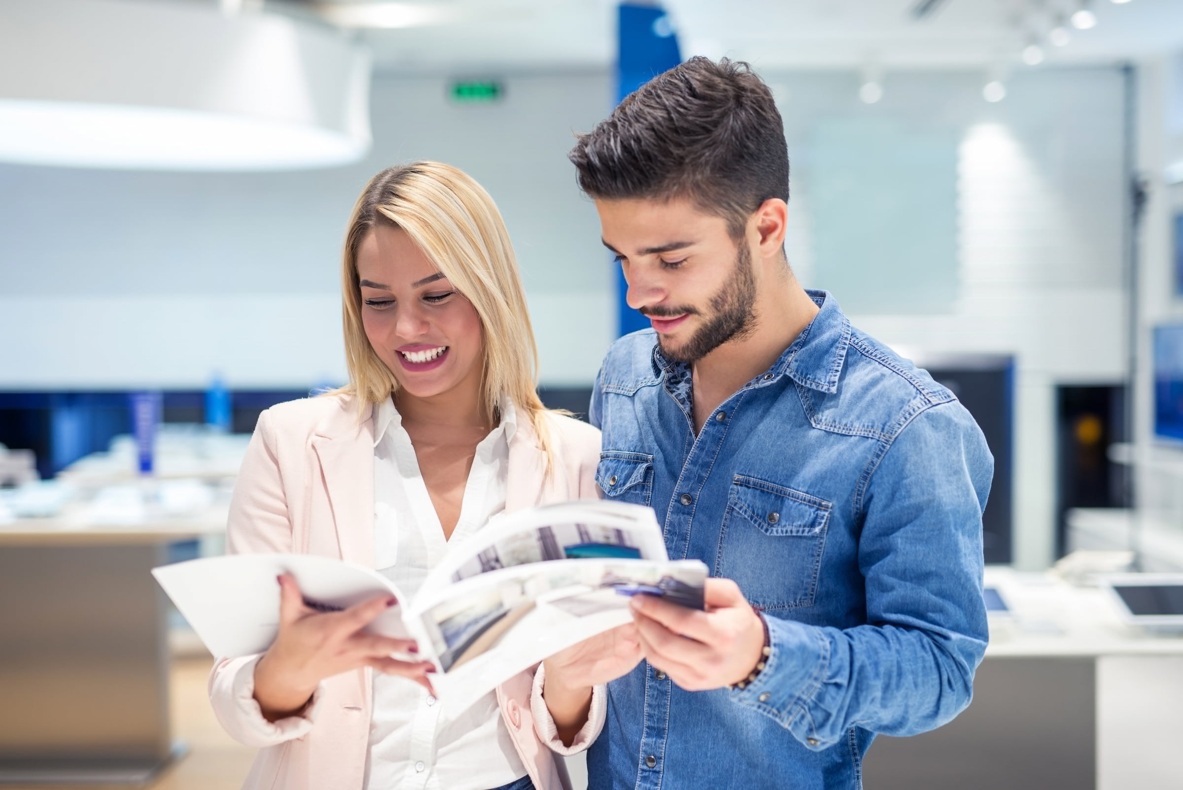 man and woman employees in corporate office reviewing print documents