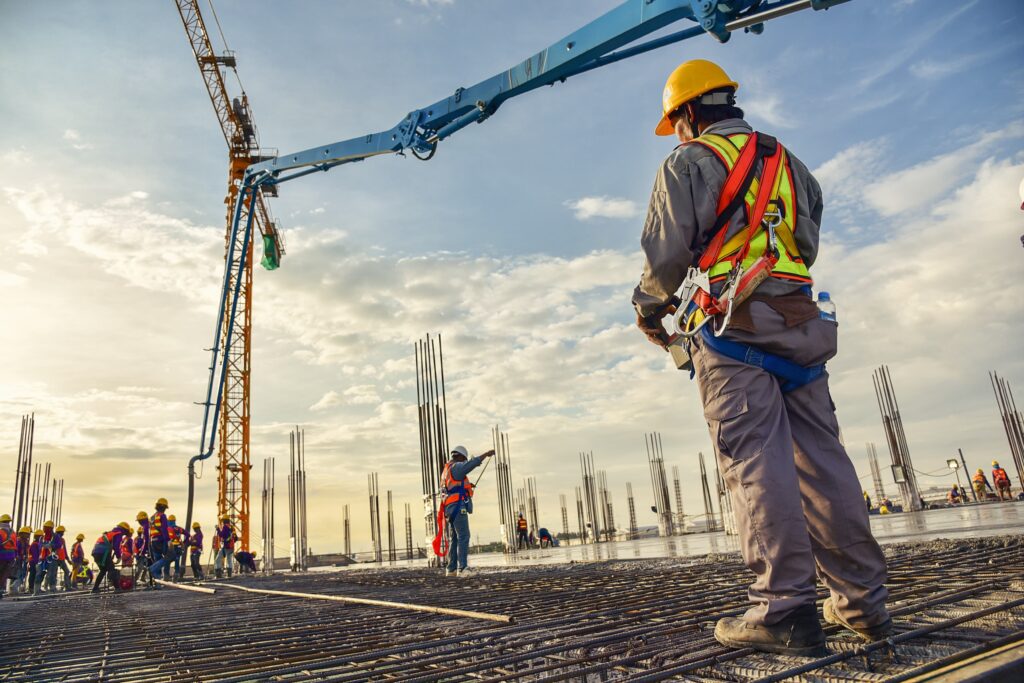 construction workers laying rebar construction crane