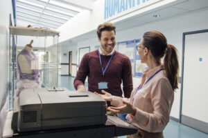 man and woman using printer photocopier in university