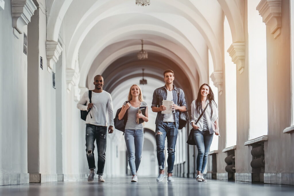 diverse university students walking down corridor