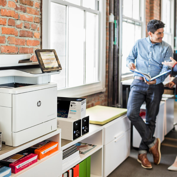 man in brick office talking by hp office printer photocopier