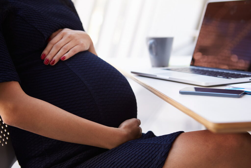 pregnant woman blue dress employee working laptop