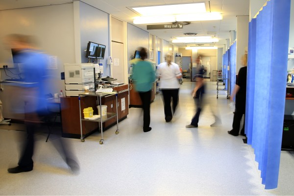 NHS staff moving through a busy hospital