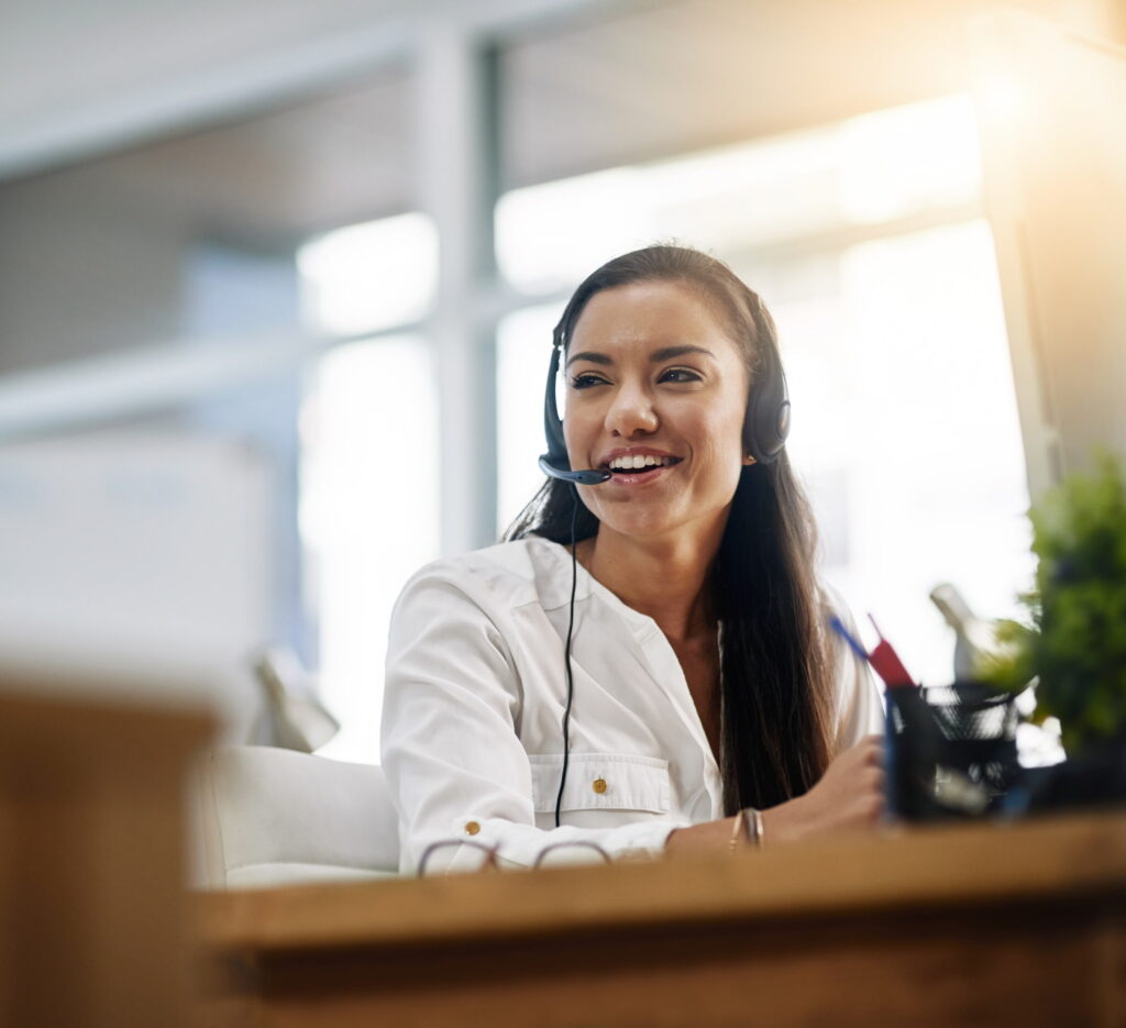woman with telecom hands free headset smiling at desk