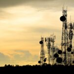 telecoms towers on a hill in the evening