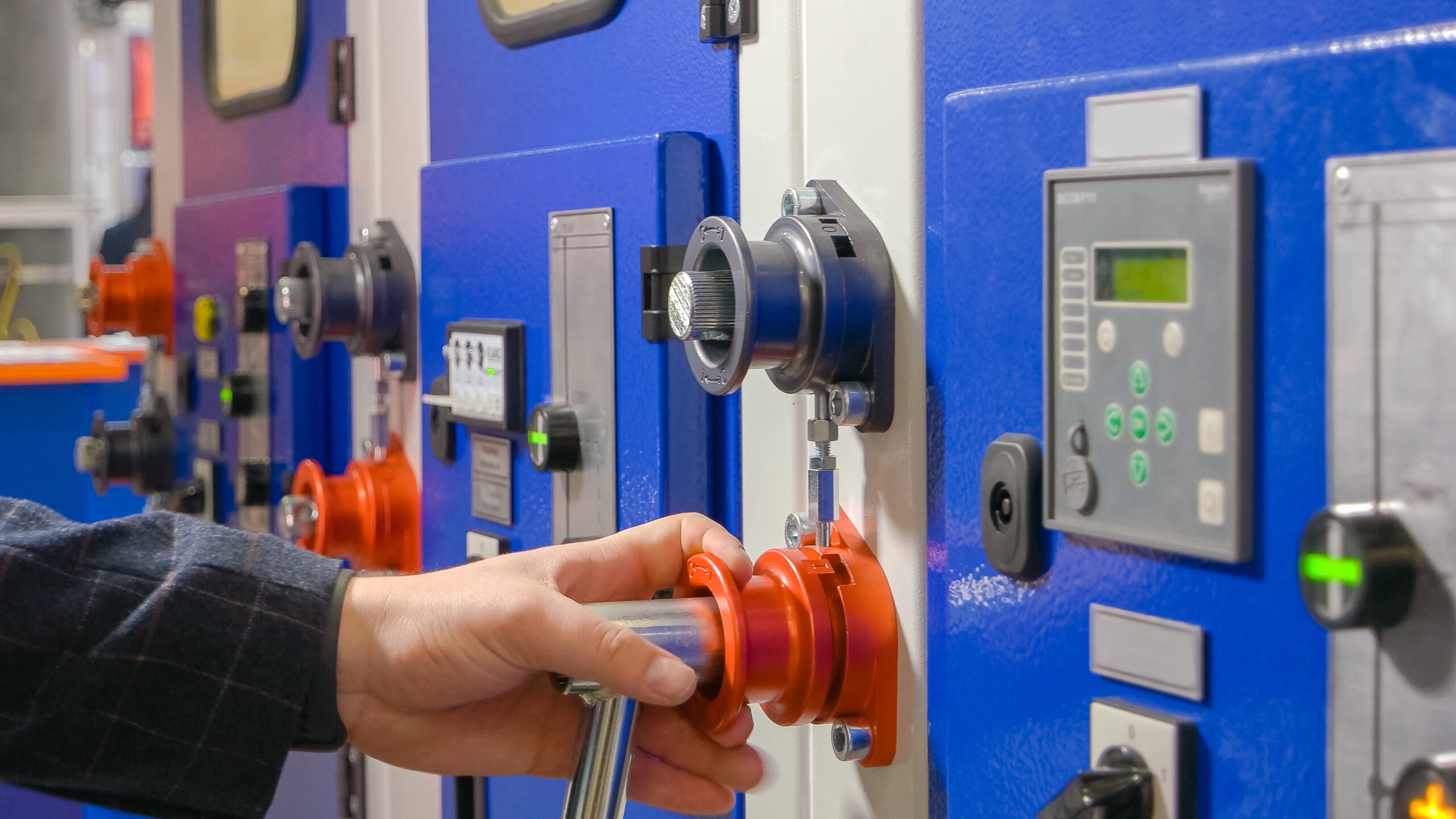 Close-up male hand screwing socket wrench on the machine panel.
