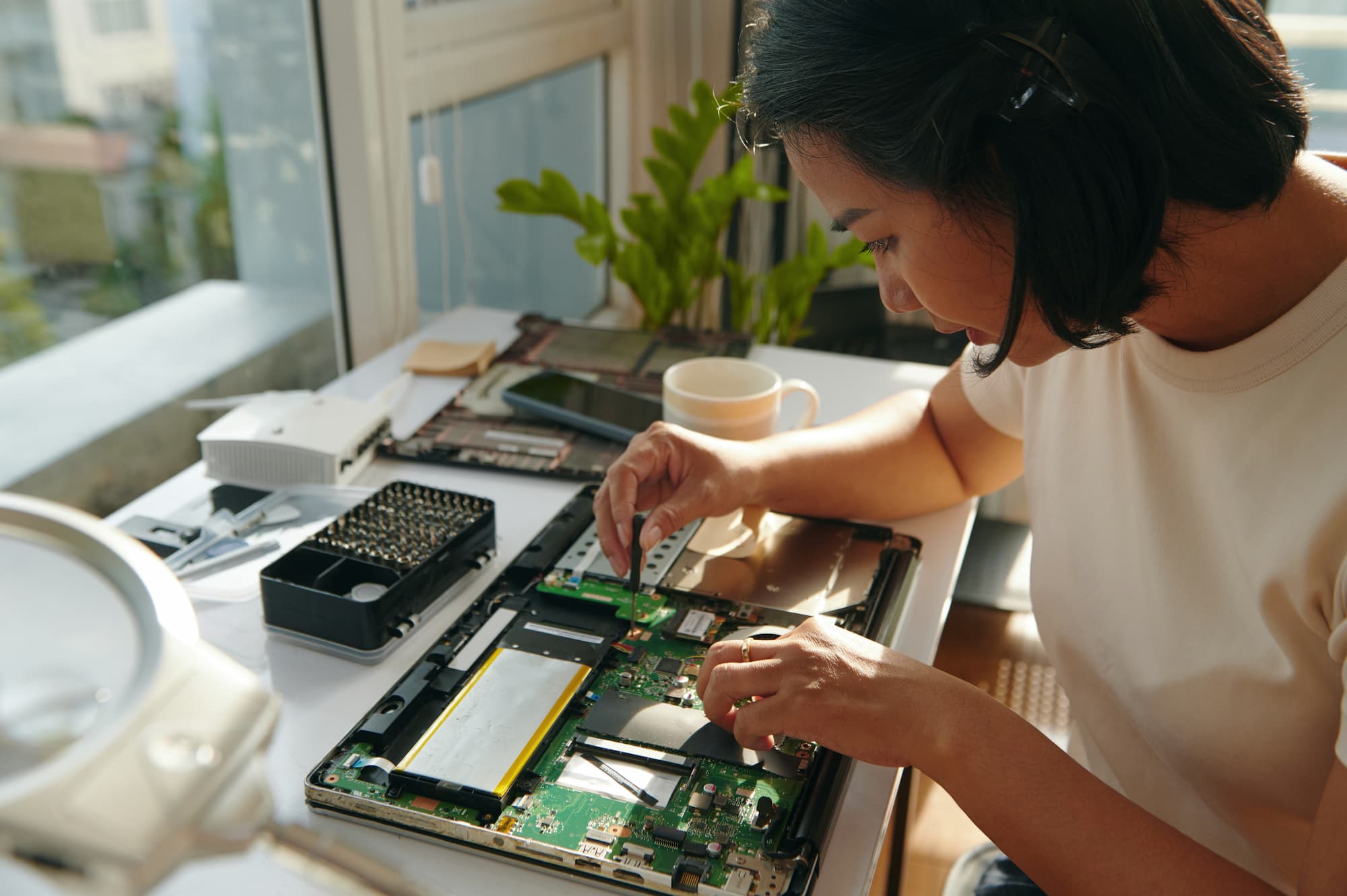 female apprentice technician fixing laptop