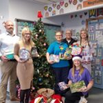 Apogee employees handing gifts to NHS staff
