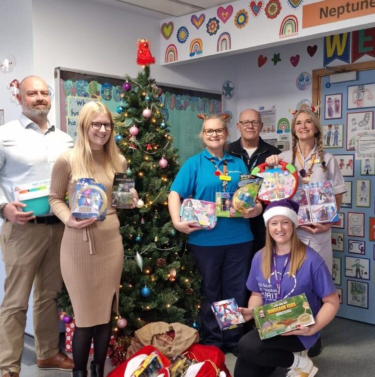 Apogee employees handing gifts to NHS staff