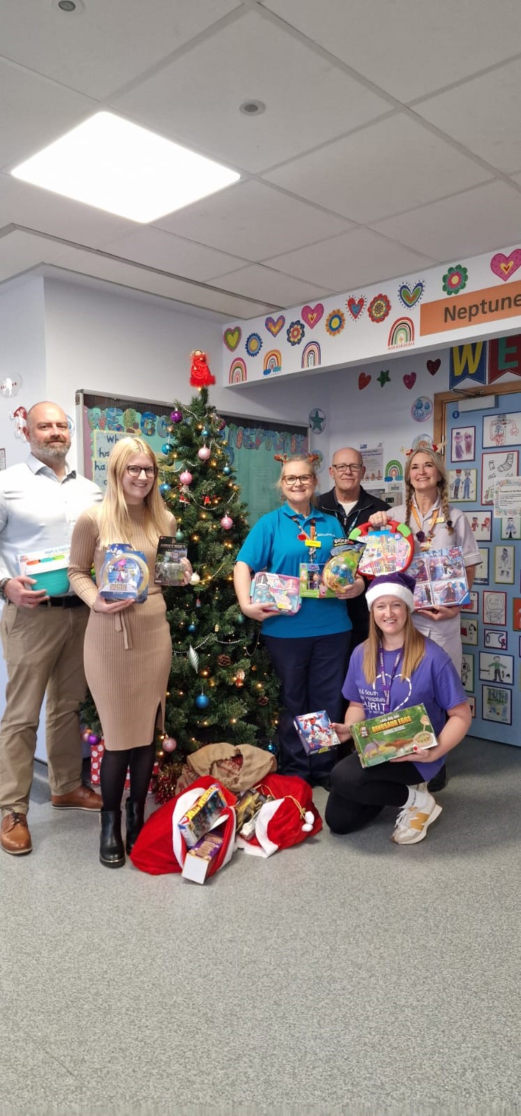 Apogee employees handing gifts to NHS staff