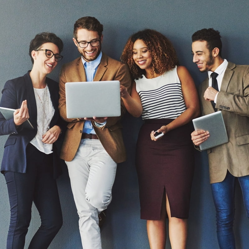 trendy young employees against grey background laptop